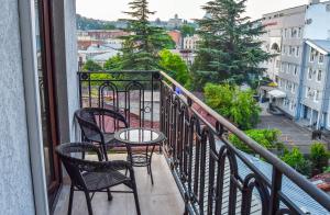 a balcony with chairs and a table on a balcony at Liliana's Apartments in Kutaisi