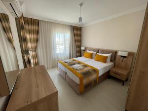 a bedroom with a large bed with yellow pillows at Alfa Apart Hotel in Antalya +122 photos