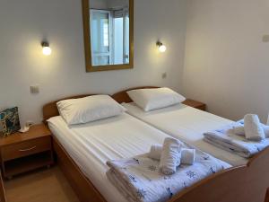 2 aparte bedden in een slaapkamer met een spiegel bij Sunrise Apartments and Studio Apartments 1 in Lokva Rogoznica