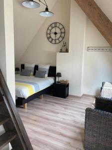 een slaapkamer met een bed en een klok aan de muur bij B&B Col del vino in Wevelgem