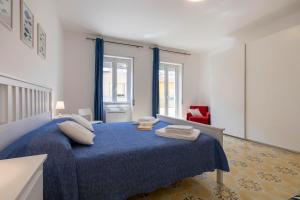 Un dormitorio con una cama azul con toallas. en San Giovanni Lido, en Alghero