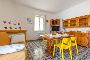 sala de estar con mesa y sillas amarillas en San Giovanni Lido, en Alghero