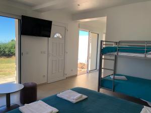 Zimmer mit einem Etagenbett, einem Tisch und einer Tür in der Unterkunft Hotel La Cigale in La Croix-Valmer