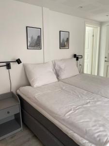 1 cama en un dormitorio con 2 lámparas en la pared en Hotel Røde-Kro, en Rødekro