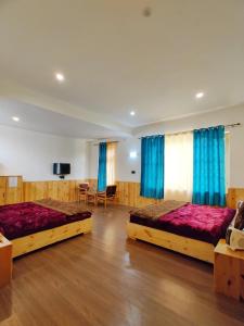 2 letti in una grande stanza con tende blu di Glacier View Guest House a Leh