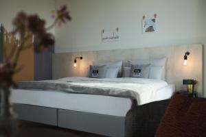 a bedroom with a large bed with white sheets and pillows at the niu Tab in Düsseldorf