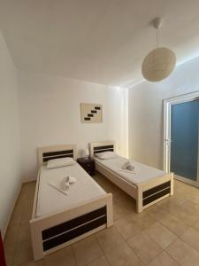 two beds in a white room with a window at Hotel Villa Ruci in Ksamil
