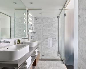 a white bathroom with two sinks and a shower at Smyth Tribeca in New York
