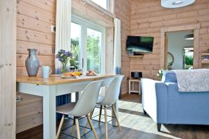 cocina y sala de estar con mesa y sillas en Cutterbrough, Great Field Lodges, en Braunton