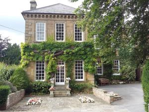 a house with ivy on the side of it at Sutton Hall Resort in Thirsk