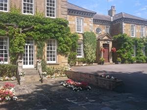 a large house with flowers in front of it at Sutton Hall Resort in Thirsk