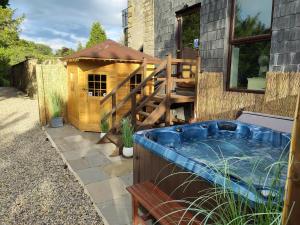 un patio trasero con bañera de hidromasaje y una casa para perros en Sutton Hall Resort, en Thirsk