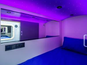 Cette chambre violette comprend un lit et un plafond violet. dans l'établissement AV-1 Capsule Hotel, à Kiev