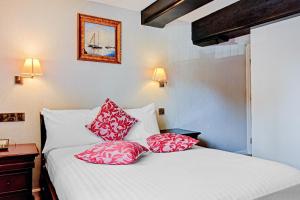 a bedroom with a bed with red and white pillows at OYO Dovecote Hotel in Birmingham
