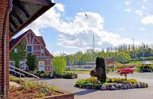 un edificio con un giardino e un uccello che vola nel cielo di Ferienwohnung mit Terrasse am Hafen in Seedorf 08 a Seedorf