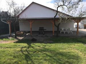 una casa con mesa de picnic y sillas en un patio en Famvarga Apartmanház, en Balatonfenyves