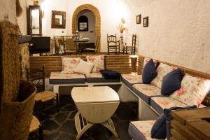 sala de estar con sofás, mesa y sillas en Hábitat Troglodita Almagruz, en Purullena