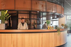 Un uomo in piedi dietro un bancone in un ristorante di the niu Tab a Dusseldorf