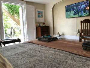 een slaapkamer met een groot bed en een televisie aan de muur bij Little Treasure with up to 25 percent off ferry in Shanklin