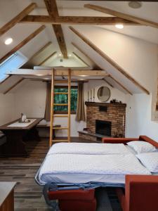 an attic bedroom with a bed and a fireplace at Zidanica Žagar in Dolenjske Toplice