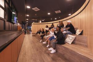 a group of people sitting in a waiting room at the niu Tab in Düsseldorf