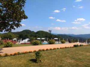 Blick auf einen Park mit Pool und Blumen in der Unterkunft Panorama Family Hotel in Slatograd