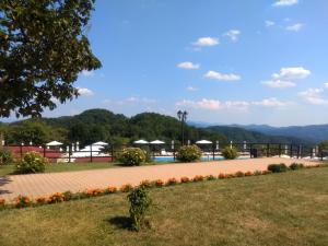 vistas a un parque con piscina y flores en Panorama Family Hotel en Zlatograd