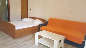 een kamer met een bed, een bank en een tafel bij Apartments Milka Pag in Pag