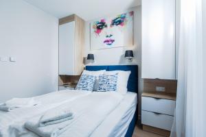 a bedroom with a bed with a blue headboard at Resort Apartamenty Klifowa Rewal 54 in Rewal +30 photos