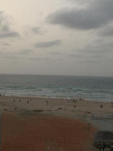 a group of people on a beach near the ocean at Sweet Home in Dakar