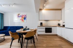 a kitchen and a living room with a table and chairs at Resort Apartamenty Klifowa Rewal 54 in Rewal