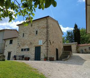 un gran edificio de ladrillo con puerta y escaleras en Agriturismo al Monte, en San Piero In Bagno