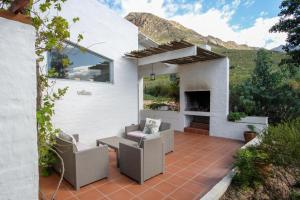 a patio with two chairs and a fireplace at Kogman & Keisie Guest Farm in Montagu