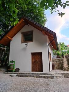 a small white house with a wooden door at Zidanica Žagar in Dolenjske Toplice +17 photos