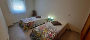 a room with two beds and a window with two candles at Apartamentos Pátio da Aldeia in Armação de Pêra