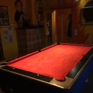 a pool table with a red cloth on it at Pension Weinsberg in Weinsberg