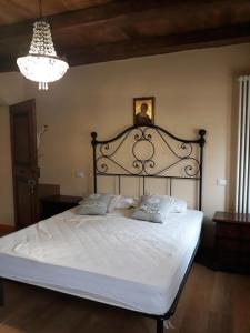 a bedroom with a large white bed with a black headboard at APPARTAMENTO FONTEBELLA in Montemarciano