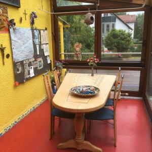 a table and chairs in a room with a window at Pension Weinsberg in Weinsberg