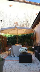 - une terrasse avec un parasol et une table fleurie dans l'établissement Vivienda uso Turístico Buscando Lino Sotosalbos, à Sotosalbos