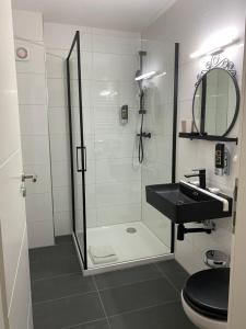 a bathroom with a glass shower and a sink at Hotel am Hafen in Mannheim