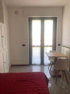 a bedroom with a bed and a desk and a table at La Casa di Anna in Delebio