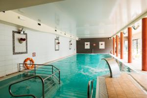 an indoor swimming pool with blue water at Hotel Chata Za Wsią in Mysłakowice