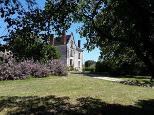 an old house with a tree in front of a yard at CHANTOISEAU in Ligueil