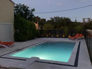 - une piscine dans une cour avec 2 chaises dans l'établissement La villa des délices, à Saint-Privat-des-Vieux