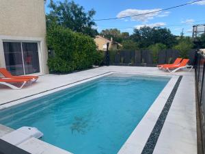 - une piscine dans une cour avec 2 chaises longues dans l'établissement La villa des délices, à Saint-Privat-des-Vieux