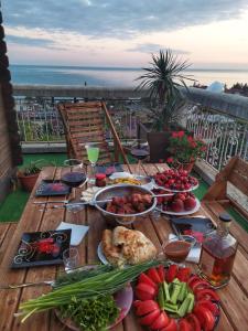 a table with plates of food on top of a balcony at Mesto pod Solntsem in Novy Afon