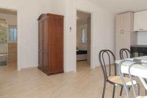 a living room with a table and chairs and a cabinet at Villa Pointe Alègre in Grimaud