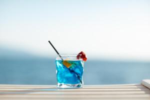 a blue drink with a cherry on a table at Hotel Jaroal in Sarandë