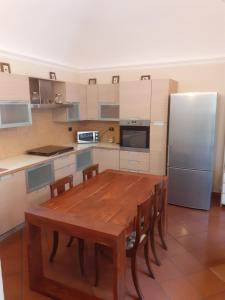 Una cocina con una mesa de madera y un refrigerador. en La Corte Dei Cappuccini, en Bérgamo