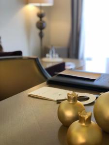 a table with a laptop and two gold balls on it at Hôtel Des Gouverneurs in Bastia